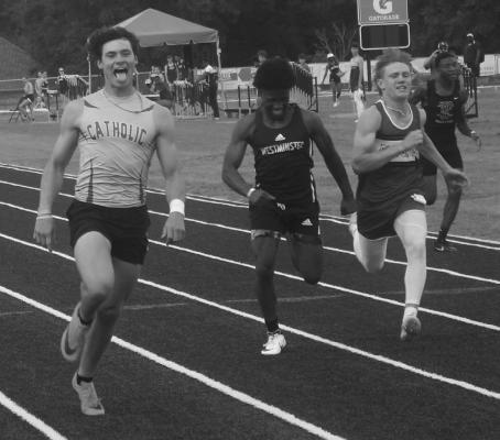 Brooks Capps of Catholic-Pc celebrates winning the 100 meters at the District 6-1A Track meet on Saturday. He also won the 200 meters and was second in the long jump. He will compete in those three events at the Region 2-1A Meet on Thursday. Photo by Kevin Fambrough